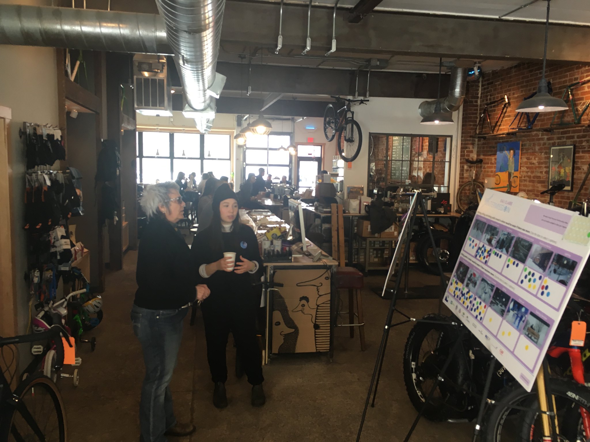 Twopeople in a bike shop looking at a poster board